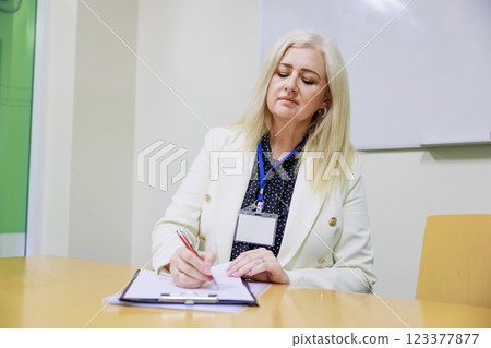 A white-haired businesswoman signing documents A white-haired businesswoman signing documents 123377877