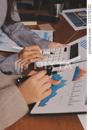 Group of confident business people point to graphs and charts to analyze market data, balance sheet, account, net profit to plan new sales strategies to increase production capacity. 123378182