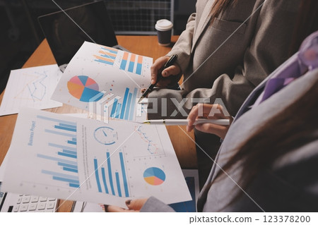 Group of confident business people point to graphs and charts to analyze market data, balance sheet, account, net profit to plan new sales strategies to increase production capacity. 123378200