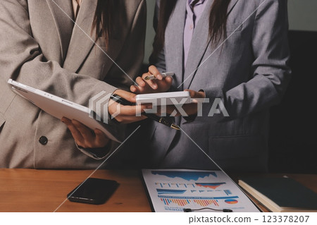 Group of confident business people point to graphs and charts to analyze market data, balance sheet, account, net profit to plan new sales strategies to increase production capacity. 123378207