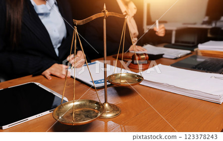 Attractive young lawyer in office Business woman and lawyers discussing contract papers with brass scale on wooden desk in office. Law, legal services, advice, Justice and real estate concept. Attractive young lawyer in office Business woman and lawyers discussing contract papers with brass scale on wooden desk in office. Law, legal services, advice, Justice and real estate concept. 123378243