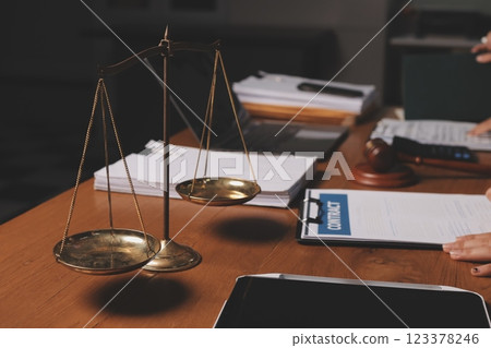 Attractive young lawyer in office Business woman and lawyers discussing contract papers with brass scale on wooden desk in office. Law, legal services, advice, Justice and real estate concept. 123378246
