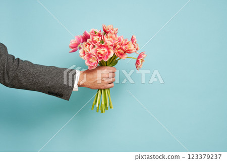 Romantic man presents a bouquet of tulips Romantic man presents a bouquet of tulips 123379237