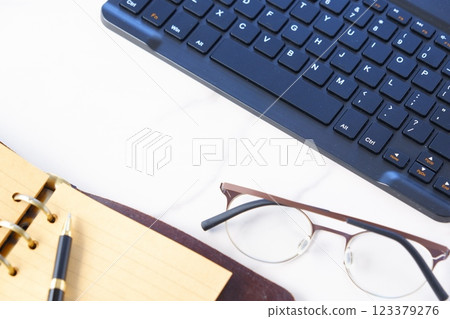 Image of a ring-type system organizer open and doing desk work on a laptop Image of a ring-type system organizer open and doing desk work on a laptop 123379276