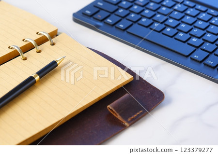 Image of a ring-type system organizer open and doing desk work on a laptop Image of a ring-type system organizer open and doing desk work on a laptop 123379277