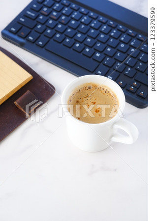 An image of a person working at a desk with a ring-type system organizer open, drinking coffee (cafe latte) and doing desk work at a computer An image of a person working at a desk with a ring-type system organizer open, drinking coffee (cafe latte) and doing desk work at a computer 123379599