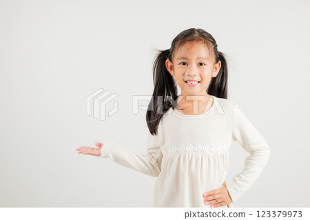 Asian happy portrait cute young girl smile presenting product holding something on palm away side, studio shot isolated on white background with copy space, kindergarten child show hand gesture Asian happy portrait cute young girl smile presenting product holding something on palm away side, studio shot isolated on white background with copy space, kindergarten child show hand gesture 123379973