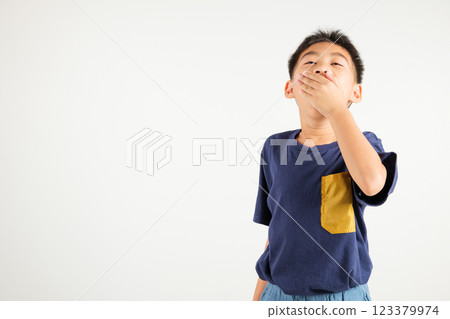 Portrait Asian young kid boy emotions tired and sleepy yawning covering mouth open by hand, studio shot isolated on white background, Thai primary child insomnia concept with copy space 123379974