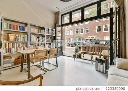 A contemporary workspace featuring a stylish table, comfortable chairs, and large windows that invite natural light, creating an inspiring atmosphere for productivity. 123380008