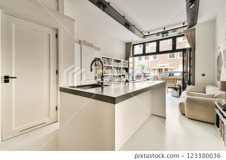 Sleek and modern kitchen featuring a minimalist design with bright lighting, clean lines, and an open layout. Perfect for contemporary living spaces. 123380036
