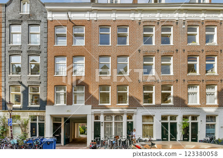 Explore a stunning view of urban architecture featuring traditional brick buildings with large windows and bicycles lining the streets, capturing a vibrant city atmosphere. 123380058