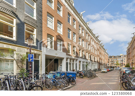 A picturesque urban street lined with bicycles and classic brick buildings under a blue sky. The inviting atmosphere showcases a vibrant city life. 123380068
