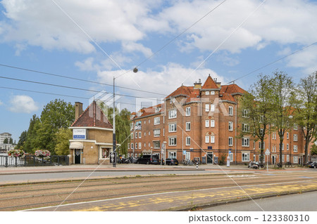Captivating view of a charming urban landscape showcasing historic architecture, trees lining the street, and vibrant blue sky. Captivating view of a charming urban landscape showcasing historic architecture, trees lining the street, and vibrant blue sky. 123380310