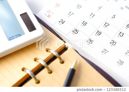 An image of someone staring at the calendar, tapping on a calculator, and eagerly waiting for the 25th, payday. An image of someone staring at the calendar, tapping on a calculator, and eagerly waiting for the 25th, payday. 123380312