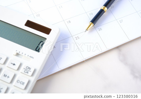 An image of someone staring at the calendar, tapping on a calculator, and eagerly waiting for the 25th, payday. An image of someone staring at the calendar, tapping on a calculator, and eagerly waiting for the 25th, payday. 123380316