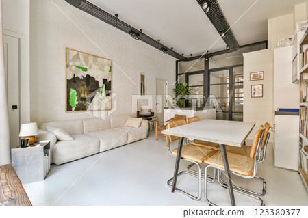 A contemporary living room featuring a cozy sofa, stylish furniture, and an elegant art piece, showcasing a blend of comfort and modern design aesthetics. 123380377