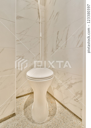 Featuring a stylish toilet against a modern marble wall backdrop and a clean, minimalist design, this image highlights contemporary bathroom aesthetics and functionality. Featuring a stylish toilet against a modern marble wall backdrop and a clean, minimalist design, this image highlights contemporary bathroom aesthetics and functionality. 123380397