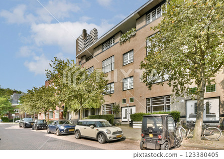 A depiction of contemporary urban buildings surrounded by lush green trees and parked cars, highlighting the balance between nature and city life. 123380405