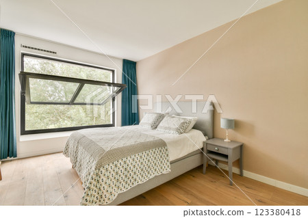 A cozy modern bedroom featuring a large window that opens outward. The room is styled with neutral tones and a comfortable bed for relaxation. A cozy modern bedroom featuring a large window that opens outward. The room is styled with neutral tones and a comfortable bed for relaxation. 123380418