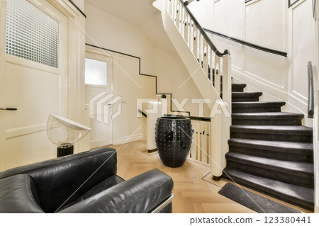 A stylish interior showcasing a modern staircase with sleek lines, warm wood flooring, and minimalist decor, perfect for contemporary homes. 123380441