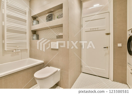 Elegant modern bathroom featuring a minimalist design with neutral tones, modern fixtures, and sleek lines, creating a stylish and functional space. Elegant modern bathroom featuring a minimalist design with neutral tones, modern fixtures, and sleek lines, creating a stylish and functional space. 123380581