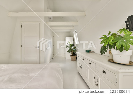 A serene minimalist interior featuring white walls, natural light, and indoor plants creating a calming atmosphere. Perfect for modern home design inspiration. 123380624