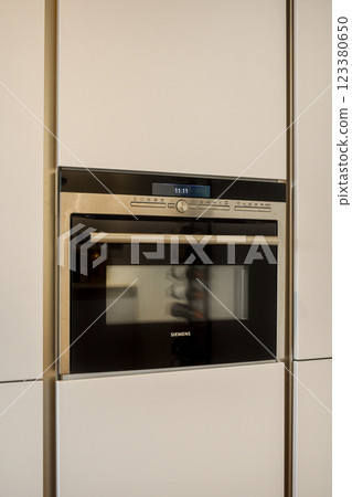 Sleek and contemporary built-in microwave oven blends seamlessly into a modern kitchen design. Features digital controls and a stylish black finish for an elegant look. 123380650