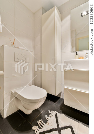 A contemporary bathroom featuring sleek fixtures, minimalist cabinetry, and stylish decor elements, creating a serene atmosphere for relaxation. 123380668