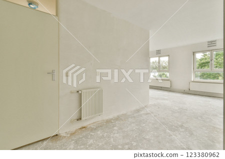 A bright, minimalist interior featuring large windows and a neutral color palette. The simplicity of the design emphasizes natural light and open space. 123380962