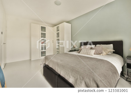 A stylish modern bedroom featuring a comfortable bed, minimalist decor, and a light color palette that promotes relaxation and tranquility. A stylish modern bedroom featuring a comfortable bed, minimalist decor, and a light color palette that promotes relaxation and tranquility. 123381001