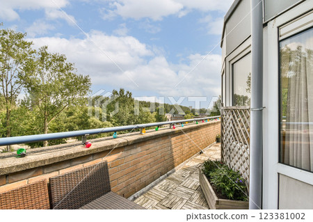 A charming balcony scene featuring a mix of greenery and a clear sky, providing a perfect outdoor escape. Ideal for relaxation and enjoying nature's beauty. A charming balcony scene featuring a mix of greenery and a clear sky, providing a perfect outdoor escape. Ideal for relaxation and enjoying nature's beauty. 123381002