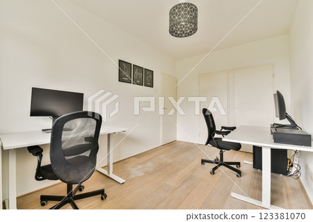 A contemporary home office featuring minimalist design with light wood flooring, modern furniture, and elegant lighting. Utilizes a neutral palette for a calming workspace. A contemporary home office featuring minimalist design with light wood flooring, modern furniture, and elegant lighting. Utilizes a neutral palette for a calming workspace. 123381070