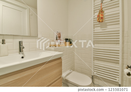 A sleek and modern bathroom showcasing minimalist elements, featuring a stylish sink, wooden cabinetry, and organized space for essentials. A sleek and modern bathroom showcasing minimalist elements, featuring a stylish sink, wooden cabinetry, and organized space for essentials. 123381071