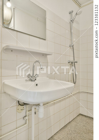 A clean and modern bathroom sink with sleek fixtures, white tiles, and a minimalistic aesthetic, perfect for contemporary design. A clean and modern bathroom sink with sleek fixtures, white tiles, and a minimalistic aesthetic, perfect for contemporary design. 123381132