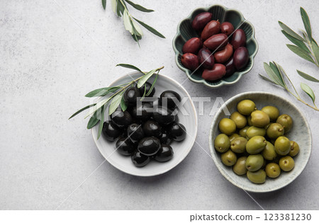Black, green and kalamata olives with olive branches on marble background 123381230