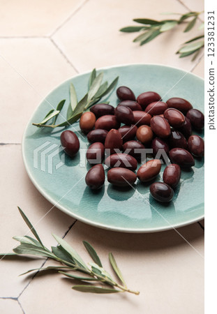 Kalamata olives with olive branches served on a modern plate 123381231