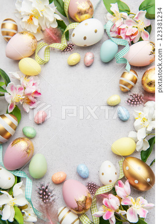 Easter eggs frame forming a circle on a gray background with flowers and feathers Easter eggs frame forming a circle on a gray background with flowers and feathers 123381234