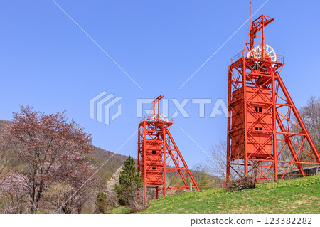 A shaft hoisting machine stands tall in the cherry blossom-filled Coal Mine Memorial Forest Park in Bibai, Hokkaido [May] 123382282