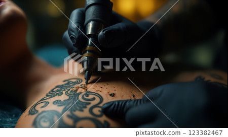 Tattoo artist drawing ornamental tattoo on woman's back 123382467