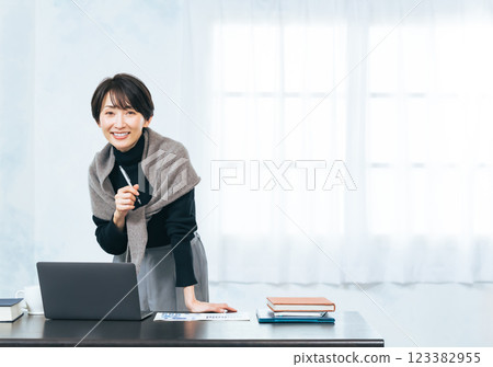Middle-aged woman working at a desk Middle-aged woman working at a desk 123382955