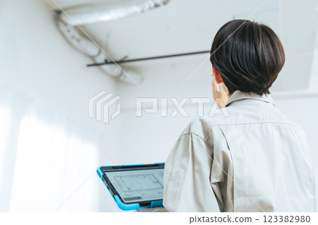 Female worker checking the building's piping Female worker checking the building's piping 123382980