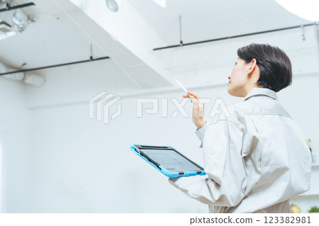 Female worker checking the interior of a building Female worker checking the interior of a building 123382981