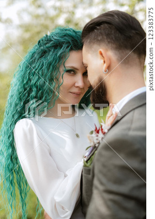 a bearded groom and a girl with green hair are walking a bearded groom and a girl with green hair are walking 123383775