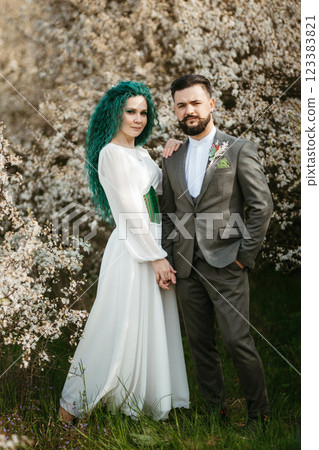 a bearded groom plays and a girl with green hair against the background of blooming spring a bearded groom plays and a girl with green hair against the background of blooming spring 123383821