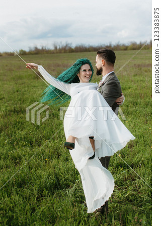 a bearded groom and a girl with green hair dance and twirl 123383875