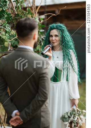 wedding ceremony of the newlyweds in a country cottage 123384363