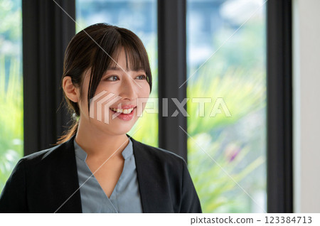Smiling woman with a laptop by the window Smiling woman with a laptop by the window 123384713