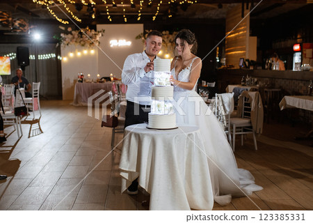 newlyweds happily cut and taste the wedding cake newlyweds happily cut and taste the wedding cake 123385331