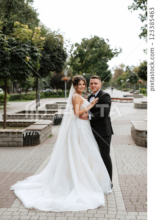 the groom in a brown suit and the bride in a white dress the groom in a brown suit and the bride in a white dress 123385463