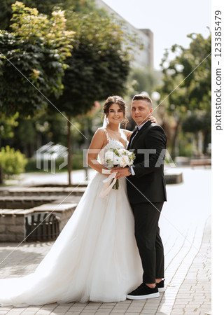 the groom in a brown suit and the bride in a white dress the groom in a brown suit and the bride in a white dress 123385479